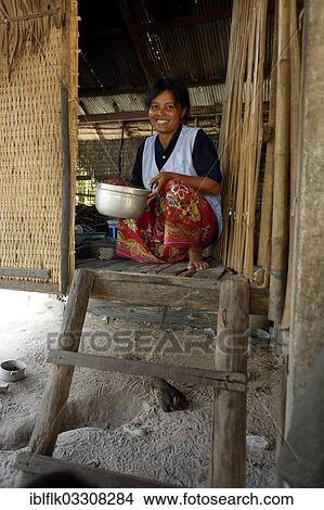 "Woman holding a pot at the entrance of her traditional stilt house made of wood and bamboo, Trapang Village, Bathi District, Takeo Province, Cambodia, Asia" View Large Photo Image Picture - "Woman holding a pot at the entrance of her traditional stilt house made of wood and bamboo, Trapang Village, Bathi District, Takeo Province, Cambodia, Asia". Fotosearch