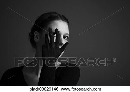 Woman holding her hand with a black glove in front of her face View Large Photo Image Stock Photograph - Woman holding her hand with a black glove in front of her face. Fotosearch