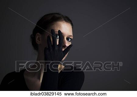 Woman holding her hand with a black glove in front of her face View Large Photo Image Stock Photography - Woman holding her hand with a black glove in front of her face. Fotosearch