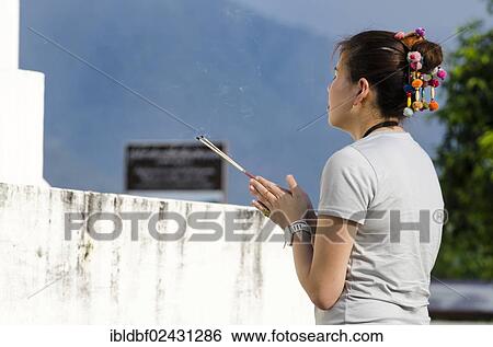 "Woman holding incense sticks, praying, Temple complex of Wat Jong Kham and Chong Kham and Wat Jong Klang and Chong Klang, Mae Hong Son, Northern Thailand, Thailand, Asia" View Large Photo Image Stock Photograph - "Woman holding incense sticks, praying, Temple complex of Wat Jong Kham and Chong Kham and Wat Jong Klang and Chong Klang, Mae Hong Son, Northern Thailand, Thailand, Asia". Fotosearch