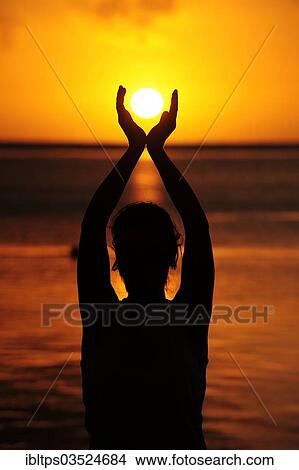 "Woman holding the sun with both her hands, sunset on the sea, La Gaulette, Mauritius, Africa" View Large Photo Image Picture - "Woman holding the sun with both her hands, sunset on the sea, La Gaulette, Mauritius, Africa". Fotosearch