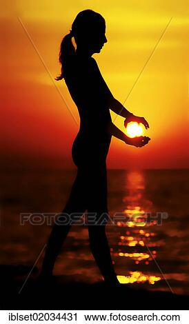 "Woman holding the sun with backlighting, silhouette of a woman at sunset" View Large Photo Image Stock Image - "Woman holding the sun with backlighting, silhouette of a woman at sunset". Fotosearch