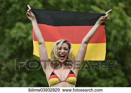 "Woman in a bikini in the German national colours holding the national flag of Germany, cheering" View Large Photo Image Stock Photo - "Woman in a bikini in the German national colours holding the national flag of Germany, cheering". Fotosearch