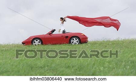 "Woman in a convertible letting a red cloth fluttering in the wind, Germany, Europe" View Large Photo Image Stock Image - "Woman in a convertible letting a red cloth fluttering in the wind, Germany, Europe". Fotosearch