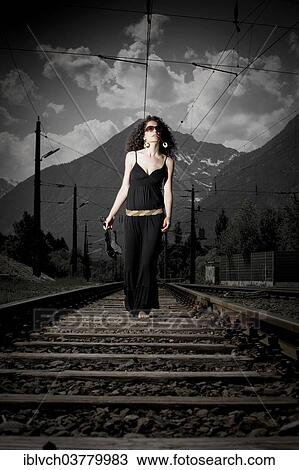 "Woman in a dress walking on railroad tracks, Tyrol, Austria, Europe" View Large Photo Image Stock Image - "Woman in a dress walking on railroad tracks, Tyrol, Austria, Europe". Fotosearch