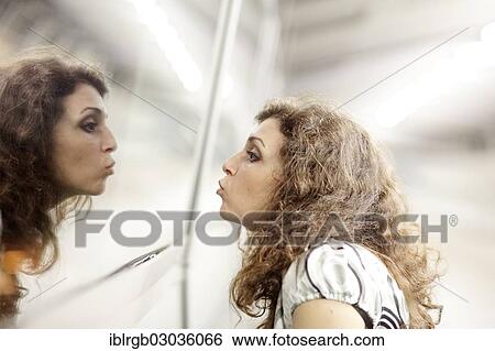 Stock Photograph - "Woman kissing her mirror image, Allgaeu, Kempten, Allgau, Swabia, Bavaria, Germany, Europe". Fotosearch