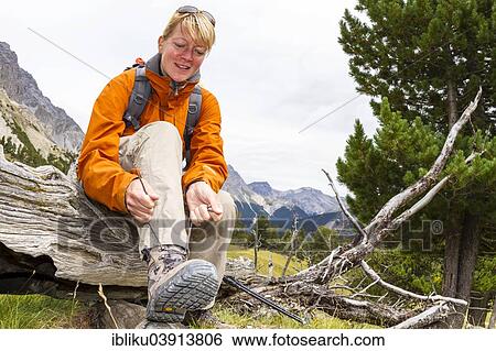 Stock Photograph - "Woman lacing her hiking boots, Val Minger, Swiss National Park, Graubunden, Switzerland, Europe". Fotosearch