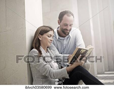 "Woman leaning against a wall and reading a book, man looking curiously into her book, Innsbruck, Tyrol, Austria, Europe" View Large Photo Image Stock Photo - "Woman leaning against a wall and reading a book, man looking curiously into her book, Innsbruck, Tyrol, Austria, Europe". Fotosearch