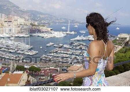 Stock Photo - "Woman looking over the marina, Port Hercule, Monte Carlo, Monaco, Europe". Fotosearch