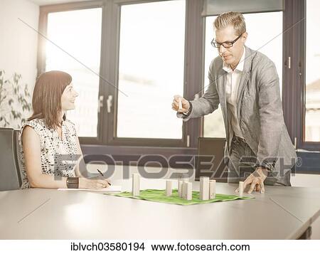 "Woman looking towards a man who is positioning figures on a system board, coaching, Innsbruck, Tyrol, Austria, Europe" View Large Photo Image Picture - "Woman looking towards a man who is positioning figures on a system board, coaching, Innsbruck, Tyrol, Austria, Europe". Fotosearch
