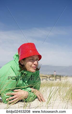 Stock Photo - "Woman lying on the beach, Sylt, Germany, Europe". Fotosearch