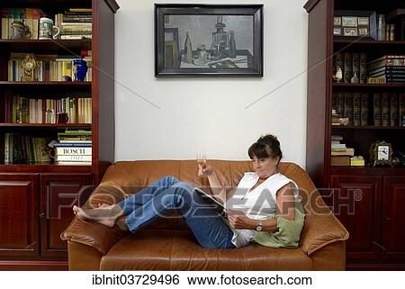 "Woman, mid 60s, drinking a glass of wine while reading" View Large Photo Image Stock Photograph - "Woman, mid 60s, drinking a glass of wine while reading". Fotosearch