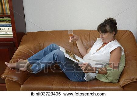 "Woman, mid 60s, drinking a glass of wine while reading" View Large Photo Image Stock Photography - "Woman, mid 60s, drinking a glass of wine while reading". Fotosearch
