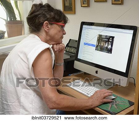 Stock Image - "Woman, mid 60s, using a computer". Fotosearch