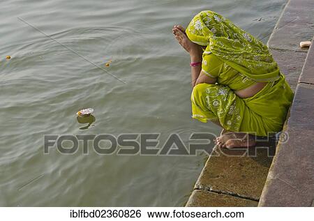 Stock Photograph - "Woman offering a Deepak to the holy river Ganges, Varanasi, India, Asia". Fotosearch