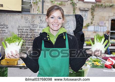 Stock Photo - "Woman offering fennel at a market stall, Esslingen am Neckar, Baden-Wuerttemberg, Germany, Europe". Fotosearch