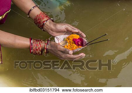 Picture - "Woman offering flowers at the Sangam, the confluence of the rivers Ganges, Yamuna and Saraswati, during Kumbha Mela, Allahabad, Uttar Pradesh, India, Asia". Fotosearch
