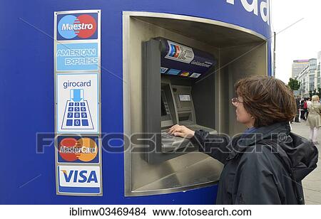 Picture - "Woman operating an EC-ATM for VISA, Maestro, American Express and girocard bank cards, Berlin, Berlin, Germany, Europe". Fotosearch
