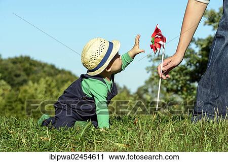 "Woman passing a pinwheel to a young boy, symbolic image for environmental education, alternative energy and sustainability" View Large Photo Image Stock Image - "Woman passing a pinwheel to a young boy, symbolic image for environmental education, alternative energy and sustainability". Fotosearch