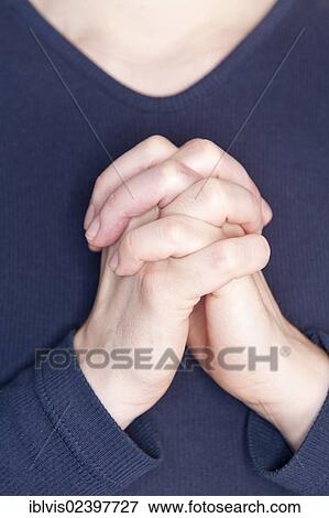 Stock Photo - Woman praying with her hands clasped. Fotosearch