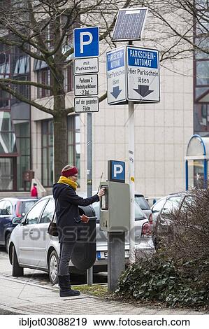 "Woman purchasing a parking ticket from a solar powered parking ticket vending machine, inner-city public parking, Essen, North Rhine-Westphalia, Germany, Europe" View Large Photo Image Stock Photo - "Woman purchasing a parking ticket from a solar powered parking ticket vending machine, inner-city public parking, Essen, North Rhine-Westphalia, Germany, Europe". Fotosearch
