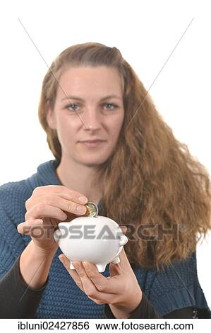 Stock Photograph - Woman putting a 2 euro coin in a piggy bank. Fotosearch