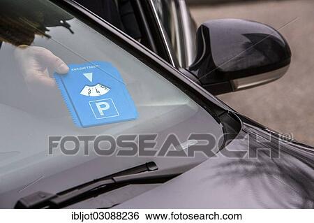 "Woman putting a parking disc with her arrival time behind the windscreen, Essen, North Rhine-Westphalia, Germany, Europe" View Large Photo Image Stock Photograph - "Woman putting a parking disc with her arrival time behind the windscreen, Essen, North Rhine-Westphalia, Germany, Europe". Fotosearch