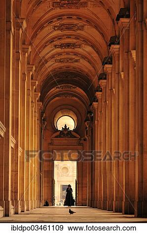 Stock Photo - "Woman setting up a tripod in an archway, Paris, Ile-de-France, France, Europe". Fotosearch