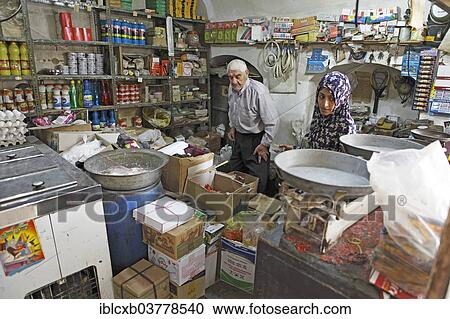 Stock Image - "Woman shopping in a typical shop in the historic centre, Yazd, Yazd Province, Persia, Iran, Asia". Fotosearch