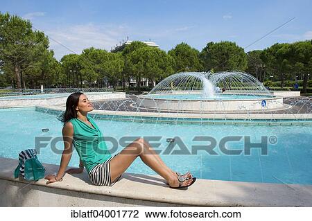"Woman sitting at a fountain, Bibione, Veneto, Italy, Europe" View Large Photo Image Stock Image - "Woman sitting at a fountain, Bibione, Veneto, Italy, Europe". Fotosearch