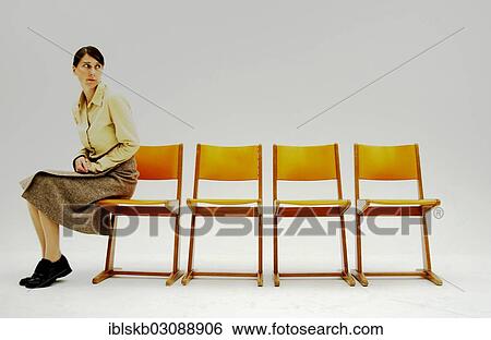 Woman sitting at the far corner intimidated with a number of old school orange chairs View Large Photo Image Stock Photograph - Woman sitting at the far corner intimidated with a number of old school orange chairs. Fotosearch
