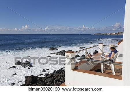 "Woman sitting on a balcony by the sea, La Puntilla, Valle Gran Rey, La Gomera, Canary Islands, Spain, Europe" View Large Photo Image Stock Image - "Woman sitting on a balcony by the sea, La Puntilla, Valle Gran Rey, La Gomera, Canary Islands, Spain, Europe". Fotosearch