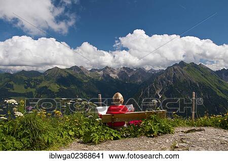 "Woman sitting on a bench, panoramic view as seen from Walmendinger Horn mountain eastwards, Allgaeu Alps, Allgaeu, Bavaria, Germany, Europe, PublicGround, Europe" View Large Photo Image Stock Image - "Woman sitting on a bench, panoramic view as seen from Walmendinger Horn mountain eastwards, Allgaeu Alps, Allgaeu, Bavaria, Germany, Europe, PublicGround, Europe". Fotosearch