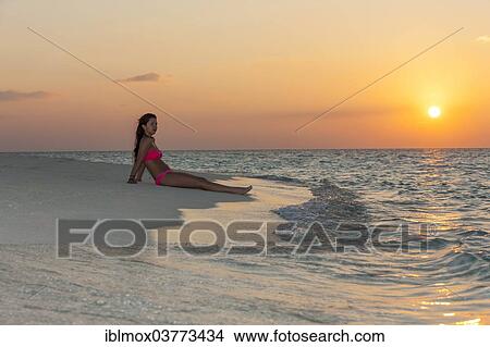 "Woman sitting on the beach at sunset, Indian Ocean, Maldives, Asia" View Large Photo Image Picture - "Woman sitting on the beach at sunset, Indian Ocean, Maldives, Asia". Fotosearch