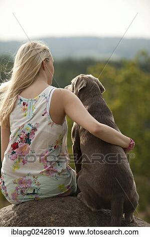 Woman sitting with a Labrador Retriever on a stone View Large Photo Image Stock Photo - Woman sitting with a Labrador Retriever on a stone. Fotosearch
