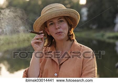 "Woman smoking a cigar on a houseboat on the Canal des Vosges, formerly Canal de l'Est, evening mood, Selles, Vesoul, Region Franche-Comte, Dep. Haute-Saone, France, Europe" View Large Photo Image Stock Image - "Woman smoking a cigar on a houseboat on the Canal des Vosges, formerly Canal de l'Est, evening mood, Selles, Vesoul, Region Franche-Comte, Dep. Haute-Saone, France, Europe". Fotosearch