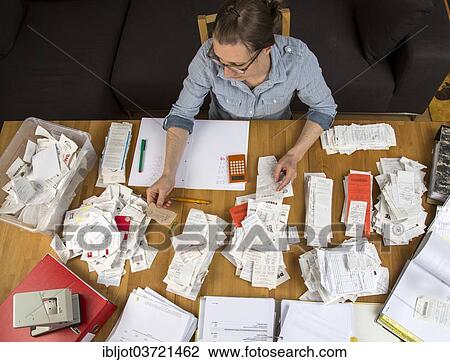 "Woman sorting documents, records, invoices and receipts on a desk, for the tax return" View Large Photo Image Stock Image - "Woman sorting documents, records, invoices and receipts on a desk, for the tax return". Fotosearch
