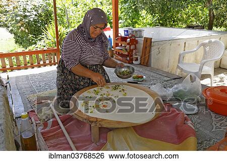 Stock Photograph - "Woman spreading the filling on Goezleme flatbread, Anatolian cuisine, Antalya Province, Turkey, Asia". Fotosearch