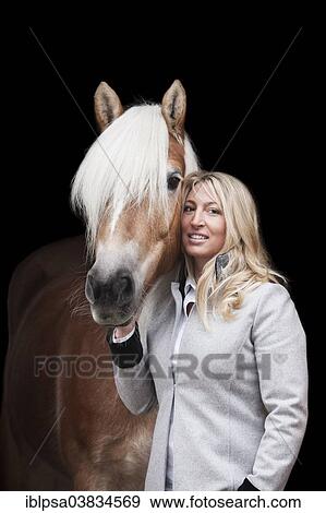 Stock Photo - "Woman standing beside a Tyrolean Haflinger, North Tyrol, Austria, Europe". Fotosearch