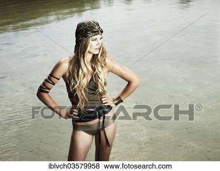 Stock Photo - "Woman standing in a lake, fashion, Lake Achen, Maurach, Tyrol, Austria, Europe". Fotosearch