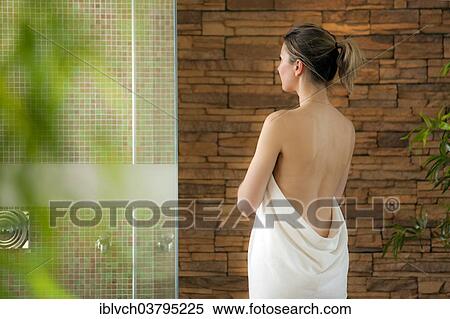 Stock Photography - Woman standing in front of a shower in a spa complex. Fotosearch