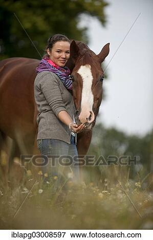 "Woman standing next to a Hanoverian horse in a meadow, Germany, Europe" View Large Photo Image Stock Photo - "Woman standing next to a Hanoverian horse in a meadow, Germany, Europe". Fotosearch
