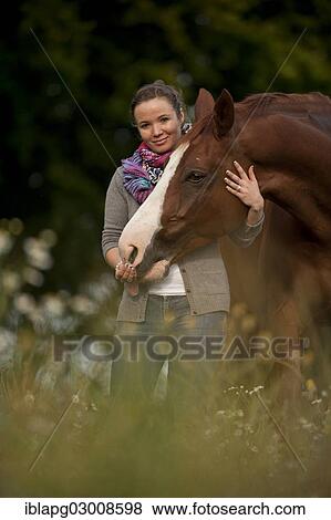 "Woman standing next to a Hanoverian horse in a meadow, Germany, Europe" View Large Photo Image Stock Photo - "Woman standing next to a Hanoverian horse in a meadow, Germany, Europe". Fotosearch