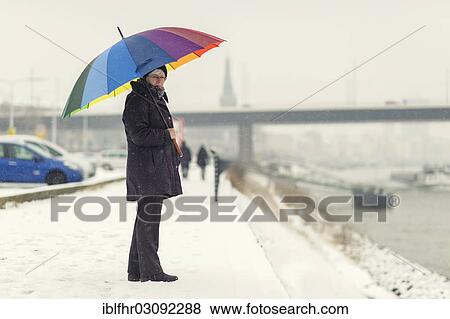 "Woman standing with a colourful umbrella in winter on the bank of the Rhine River, Dusseldorf, Rhineland, North Rhine-Westphalia, Germany, Europe" View Large Photo Image Stock Photo - "Woman standing with a colourful umbrella in winter on the bank of the Rhine River, Dusseldorf, Rhineland, North Rhine-Westphalia, Germany, Europe". Fotosearch