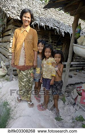 "Woman standing with three girls in front of a hut made of wood and straw, Trapang Village, Bathi District, Takeo Province, Cambodia, Asia" View Large Photo Image Stock Photo - "Woman standing with three girls in front of a hut made of wood and straw, Trapang Village, Bathi District, Takeo Province, Cambodia, Asia". Fotosearch