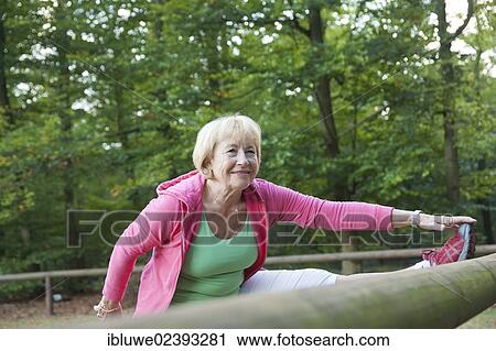 Woman stretching on an outdoor fitness trail View Large Photo Image Stock Image - Woman stretching on an outdoor fitness trail. Fotosearch