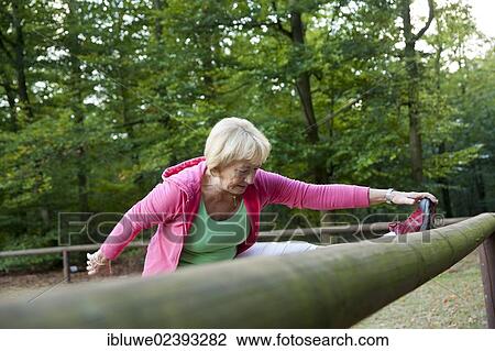 Woman stretching on an outdoor fitness trail View Large Photo Image Stock Image - Woman stretching on an outdoor fitness trail. Fotosearch