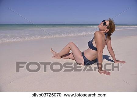 "Woman sunbathing at the beach, Dongwe Beach, Dongwe, Zanzibar, Tanzania, Africa" View Large Photo Image Stock Image - "Woman sunbathing at the beach, Dongwe Beach, Dongwe, Zanzibar, Tanzania, Africa". Fotosearch
