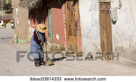 Stock Image - "Woman sweeping outside her house, Putre, northern Chile". Fotosearch