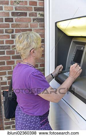 Stock Photo - Woman using an ATM. Fotosearch
